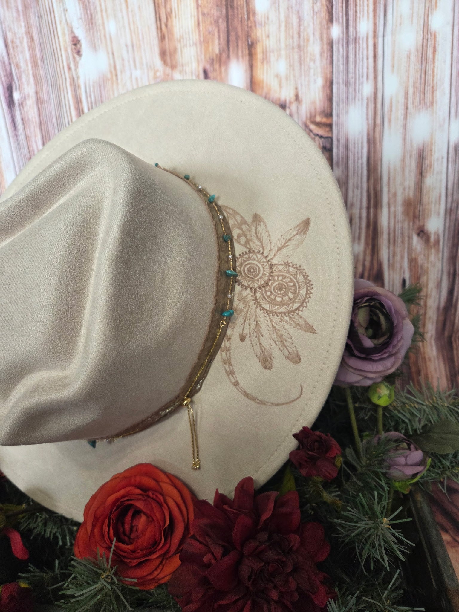 Beige hat with floral design on a wooden background