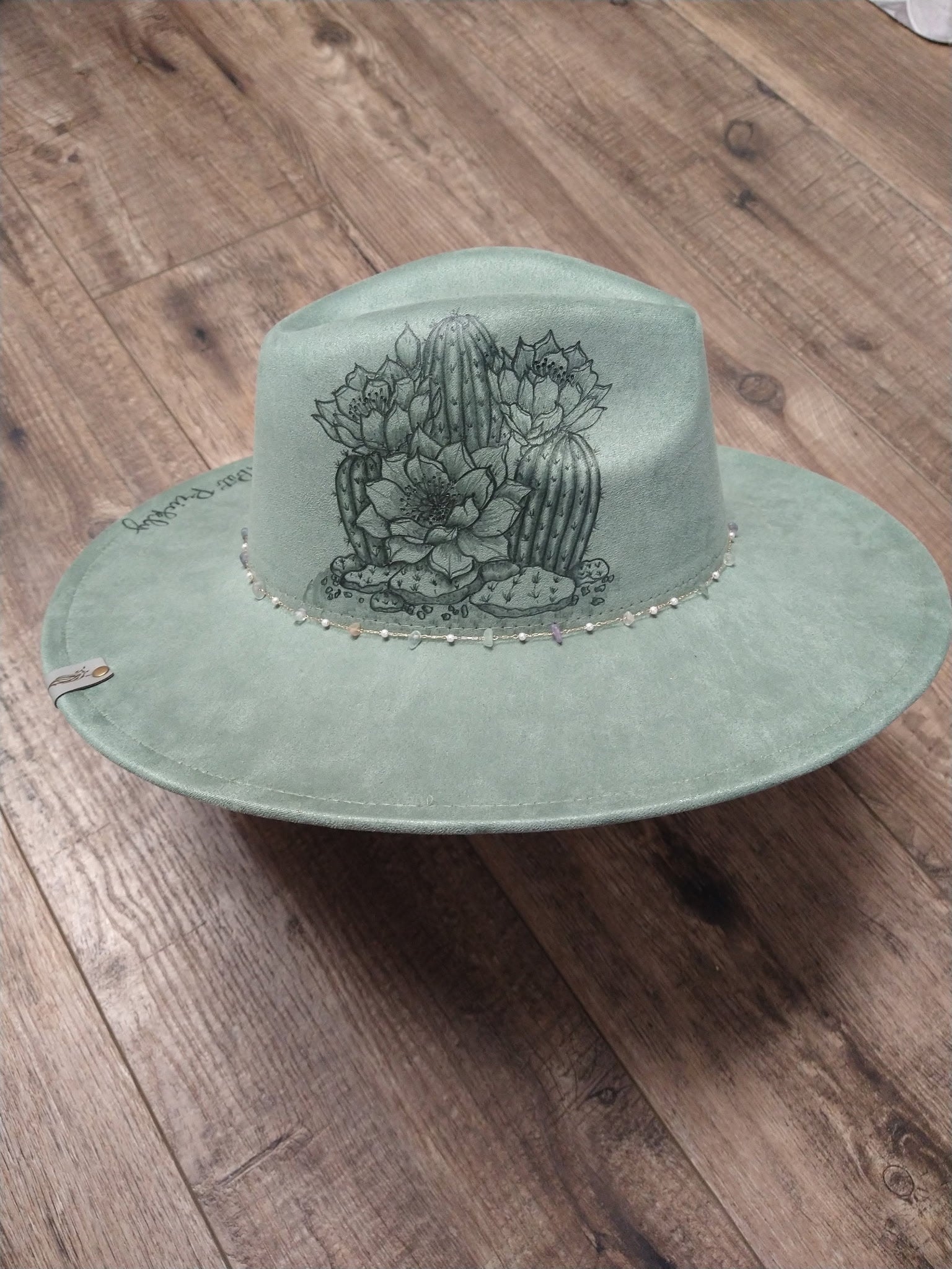 Green hat with cactus design on a wooden surface