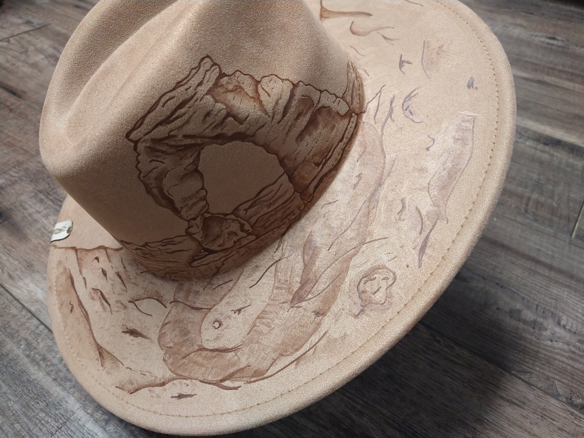 Beige hat with engraved design on a wooden surface