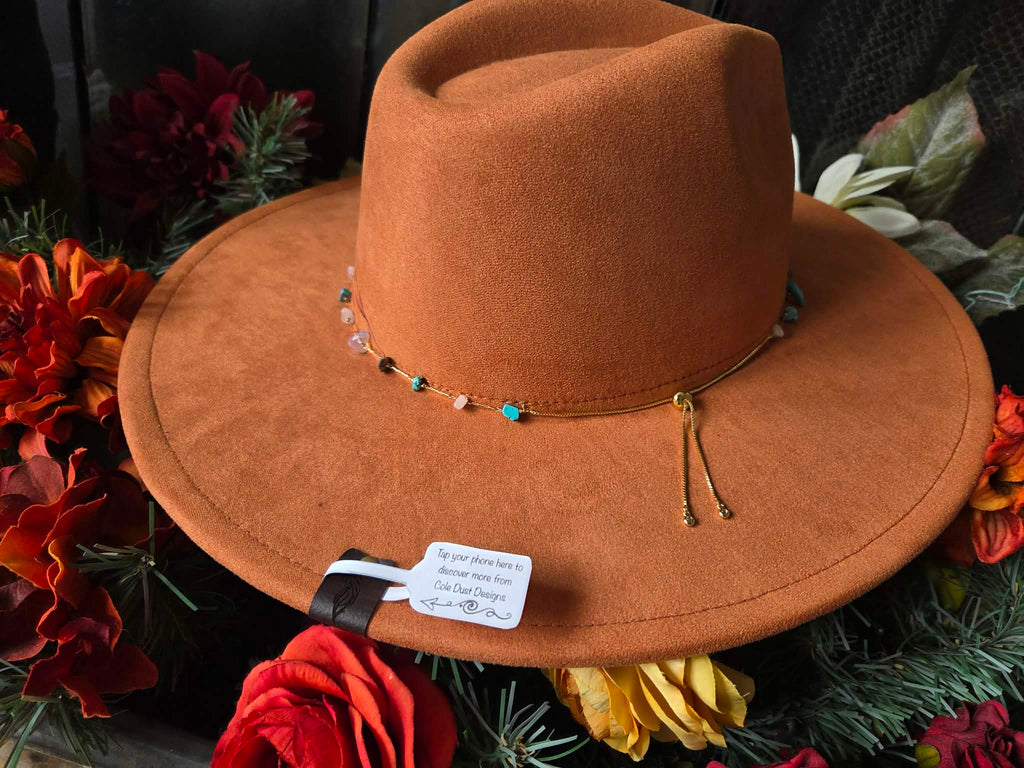 Orange cowboy hat with decorative elements on a floral background