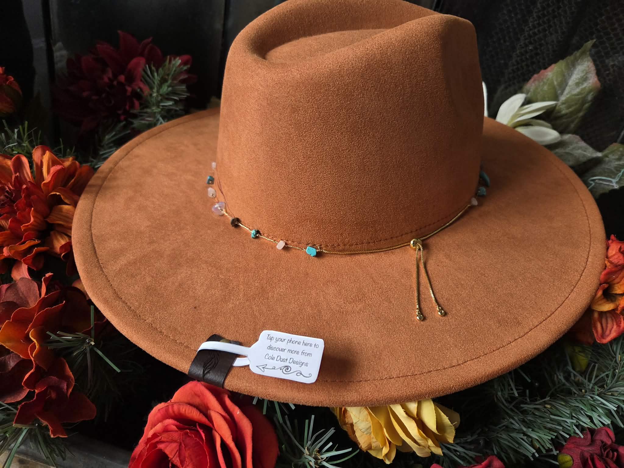 Orange cowboy hat with decorative elements on a floral background