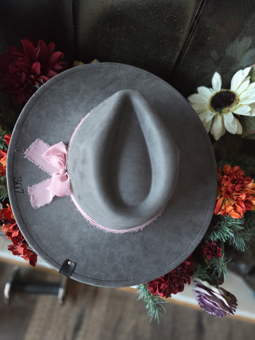 Gray hat with a pink ribbon on a floral background