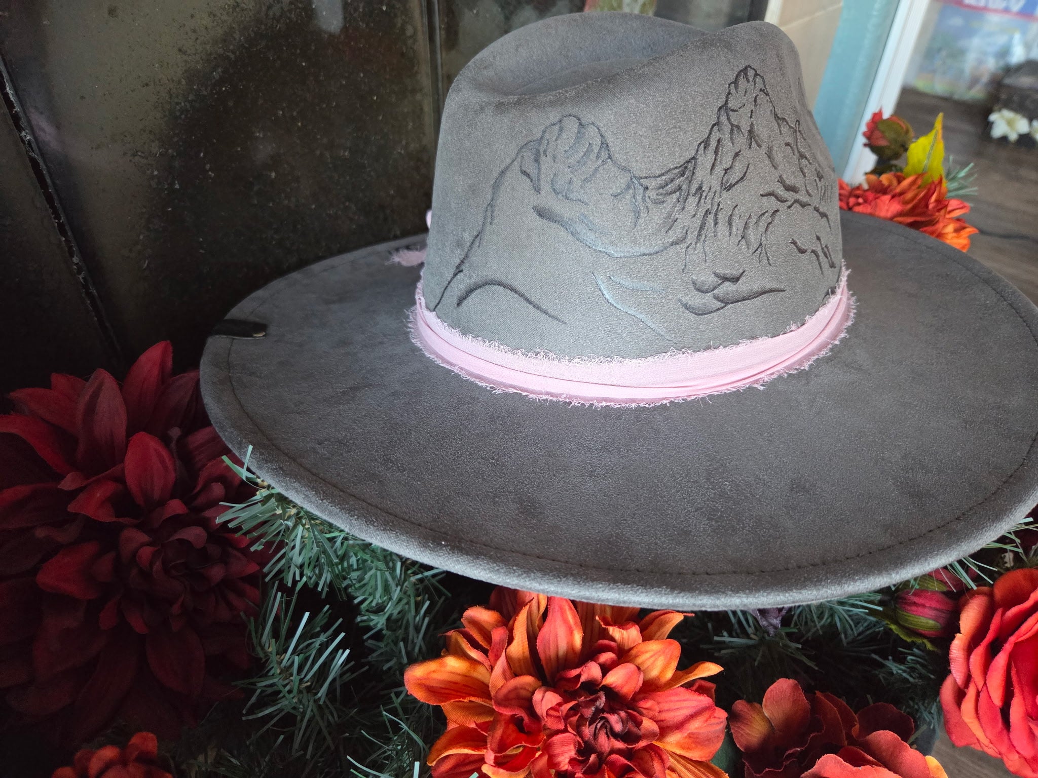 Gray cowboy hat with pink band on a floral background
